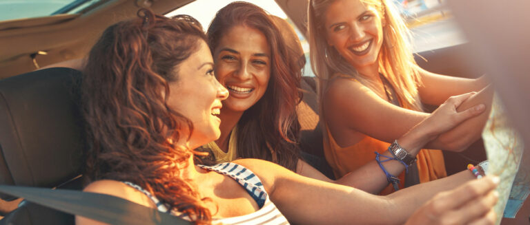 three women in a car laughing